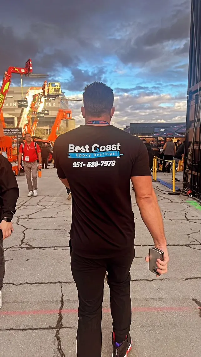 Ryan Pepple in a Best Coast Epoxy Coatings shirt walking a trade show floor